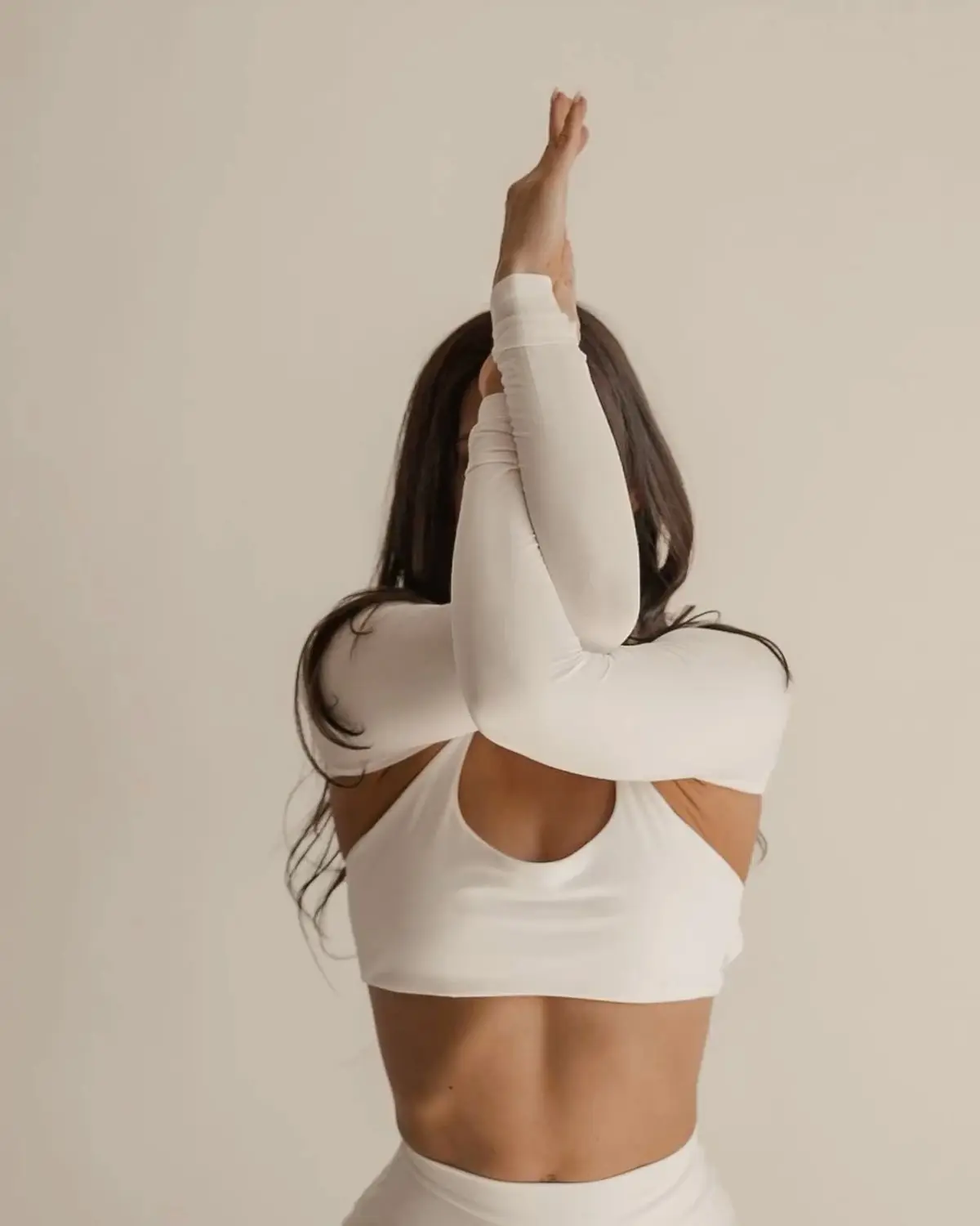 A woman standing calmly in a sunlit studio